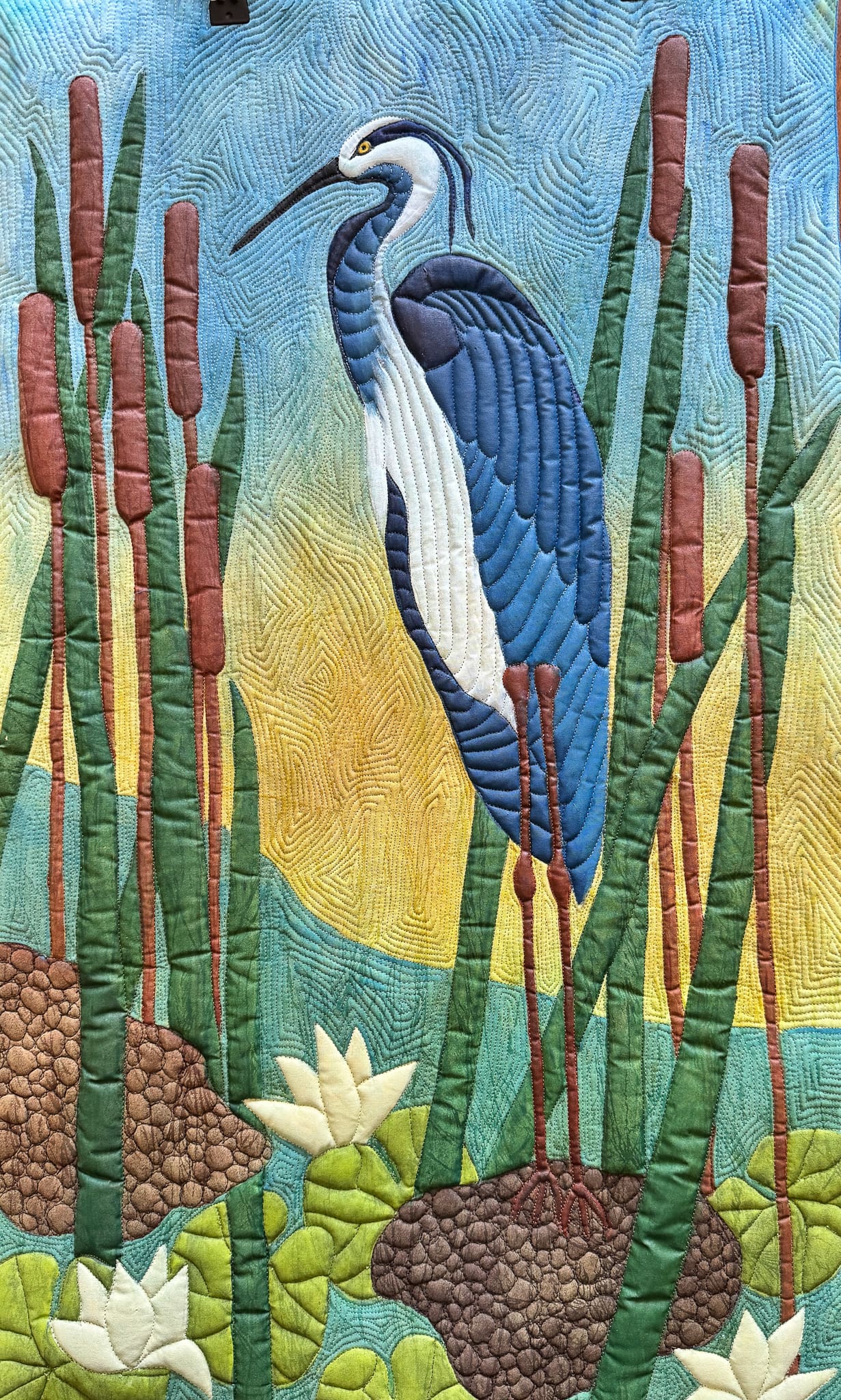 A colorful mosaic of a blue heron among cattails and water plants.